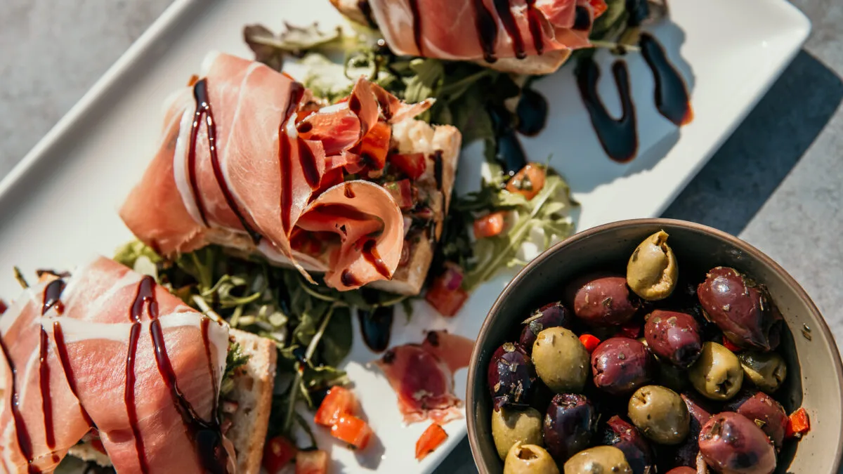 Smaakvolle lunch, knapperig brood met romige topping, omhuld met zachte Parmaham en balsamico